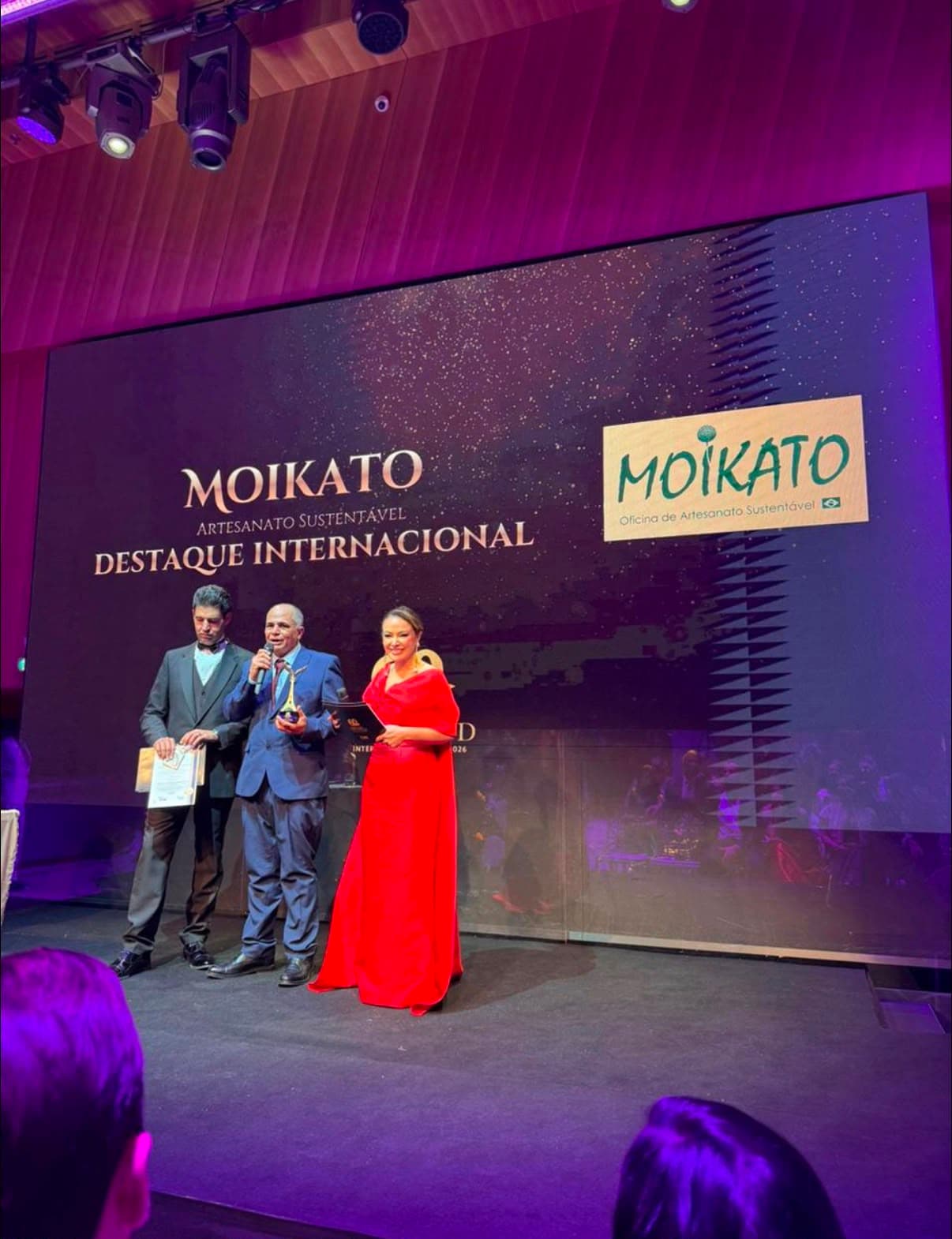 Samuel Moikato recebendo no palco o reconhecimento de Destaque Internacional