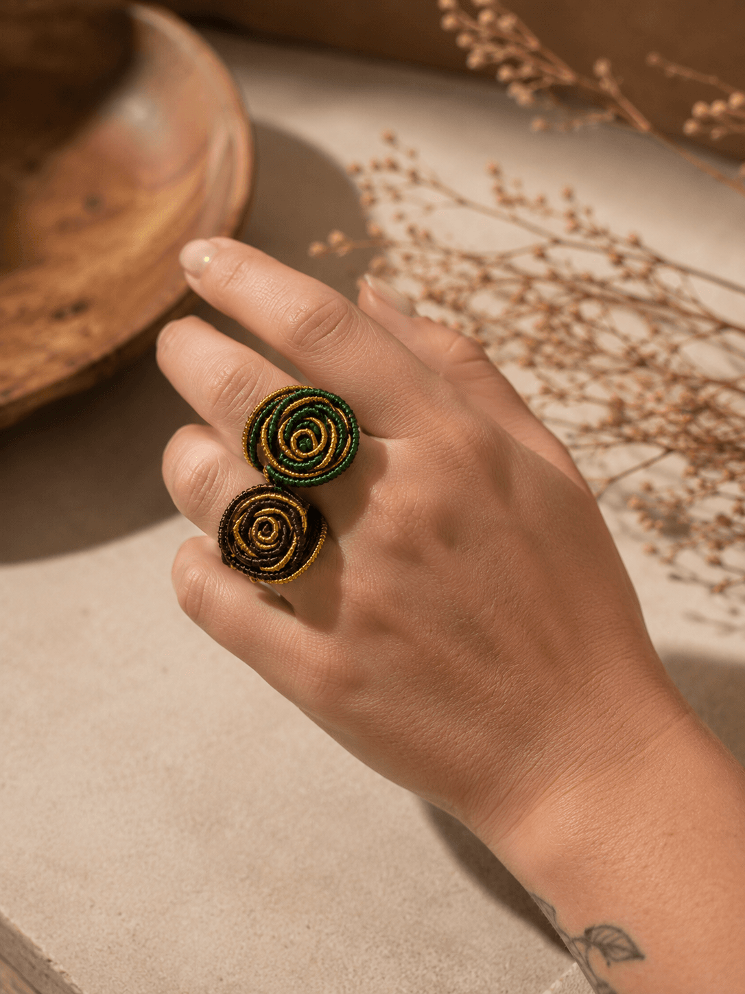 Dois anéis Espiral artesanais em capim dourado com detalhes verdes e terrosos