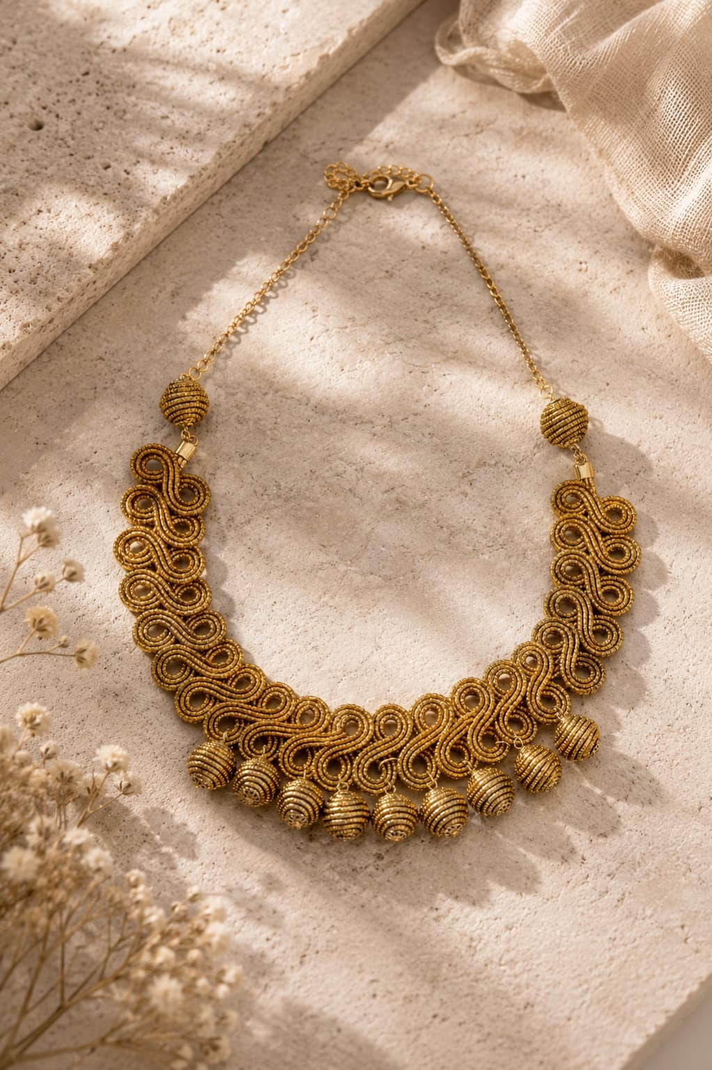 Colar Elo em capim dourado com curvas entrelaçadas e esferas artesanais